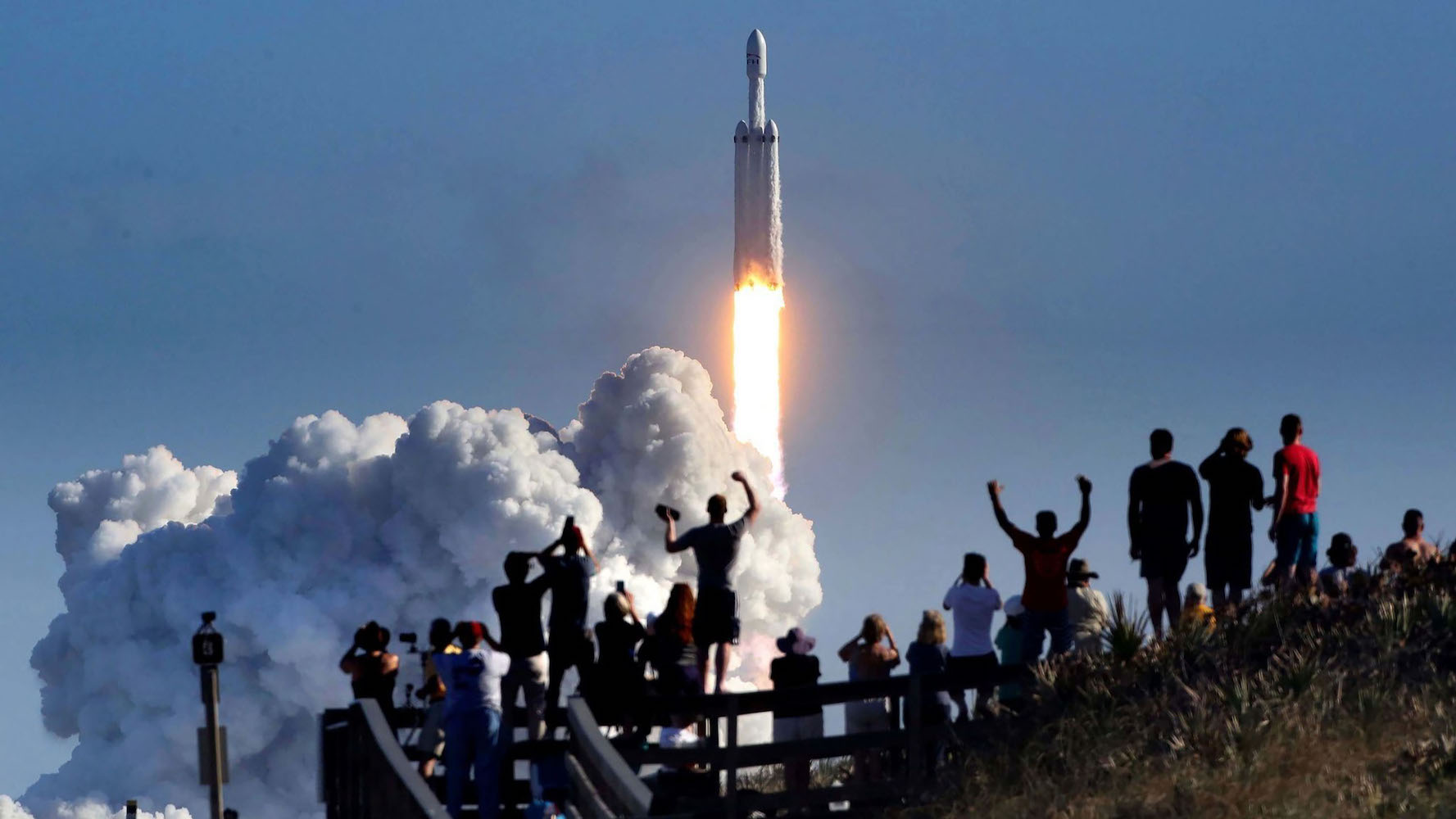 La multitud vitorea en Playalinda Beach en la costa nacional de Cañaveral, justo al norte del Centro Espacial Kennedy, durante el lanzamiento del cohete SpaceX Falcon Heavy, el 6 de febrero de 2018. Playalinda es uno de los puntos de observación pública más cercanos para ver el lanzamiento. a unas 3 millas de la plataforma de lanzamiento SpaceX 39-A.  (Joe Burbank/Orlando Sentinel/Tribune News Service vía Getty Images)