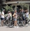 Un grupo de turistas escucha las instrucciones de su guía mientras realizan este martes un recorrido en bicicleta por el centro de Valencia