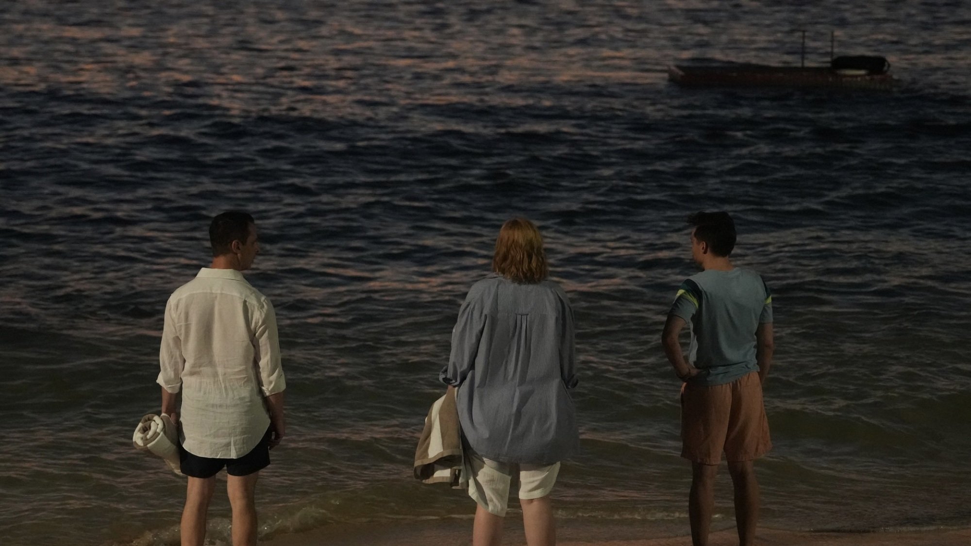 Los hermanos Roy se paran en una playa con vista al océano.