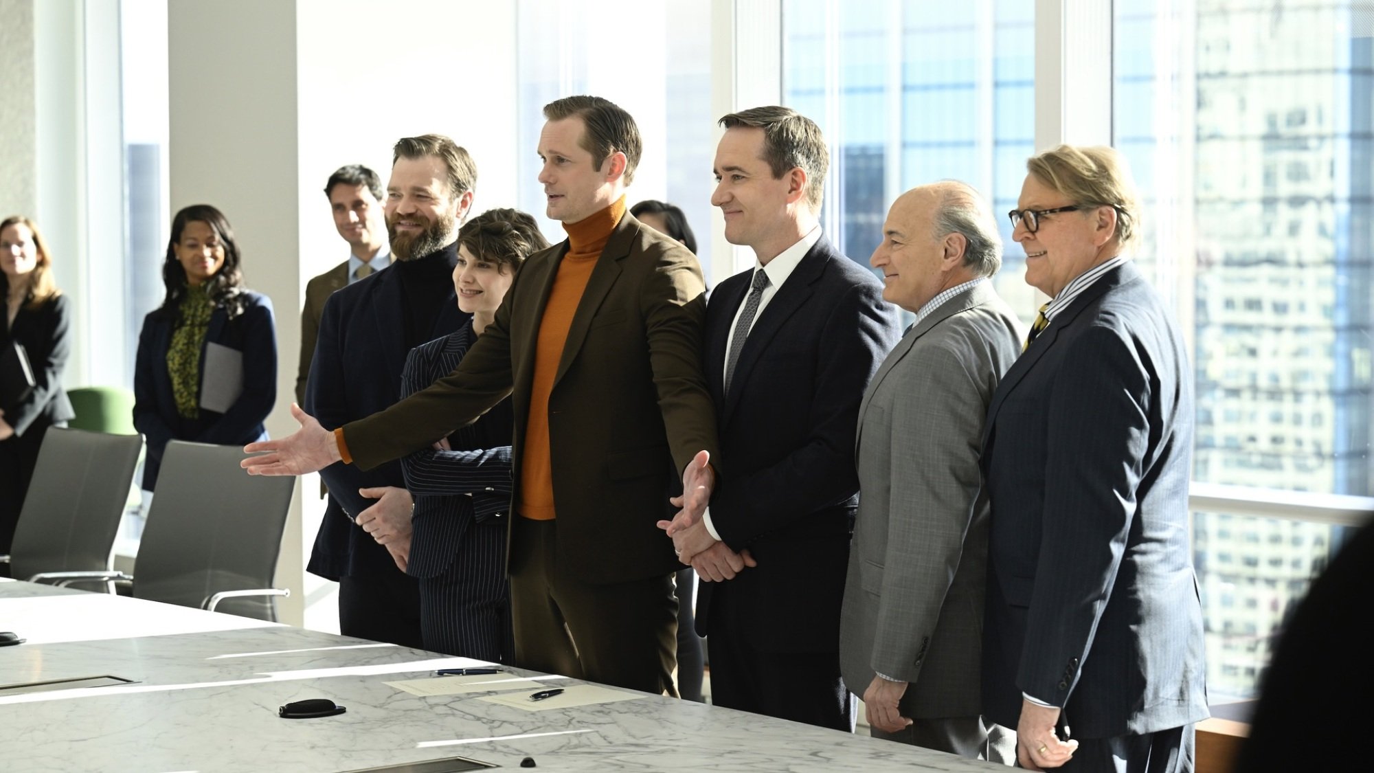 Un grupo de empresarios se reúne para una foto alrededor de documentos firmados en una mesa.
