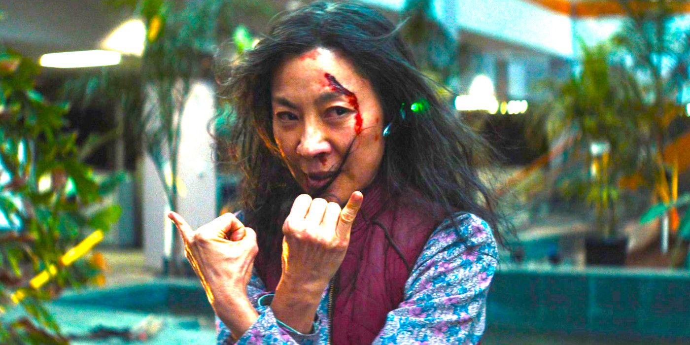 Michelle Yeoh en Everything Everywhere All At Once en un centro comercial haciendo gestos con las manos con los dedos meñiques hacia arriba, el cabello revuelto y la cara abierta.
