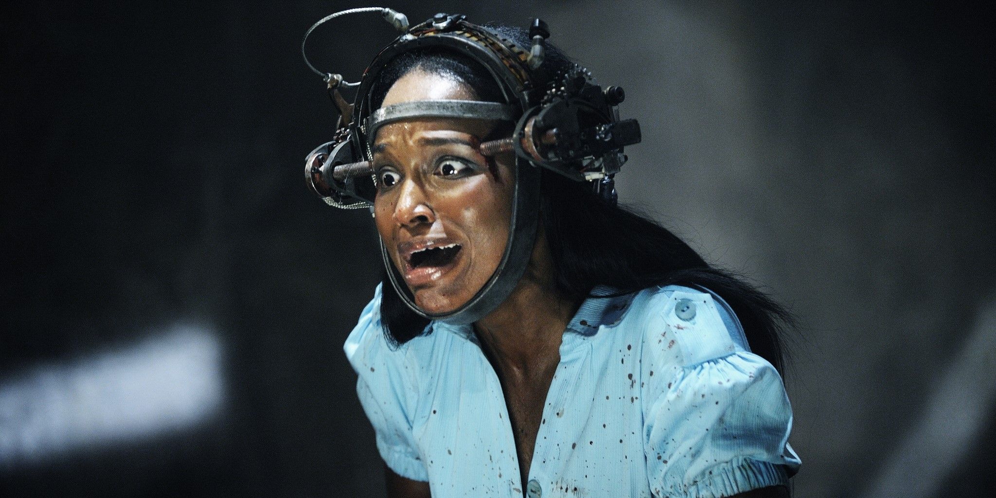 Imagen fija de Saw VI: Simone (Tanedra Howard) usa un artilugio con cabeza de metal y grita.