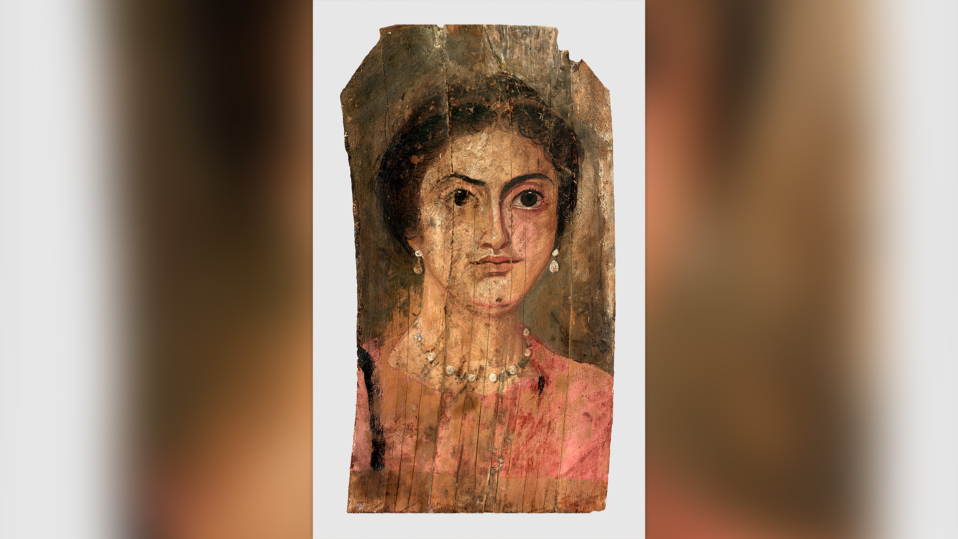 Este retrato, pintado sobre madera entre los años 175 y 200 d. C., muestra a una mujer de cabello oscuro que lleva un collar y aretes a juego.