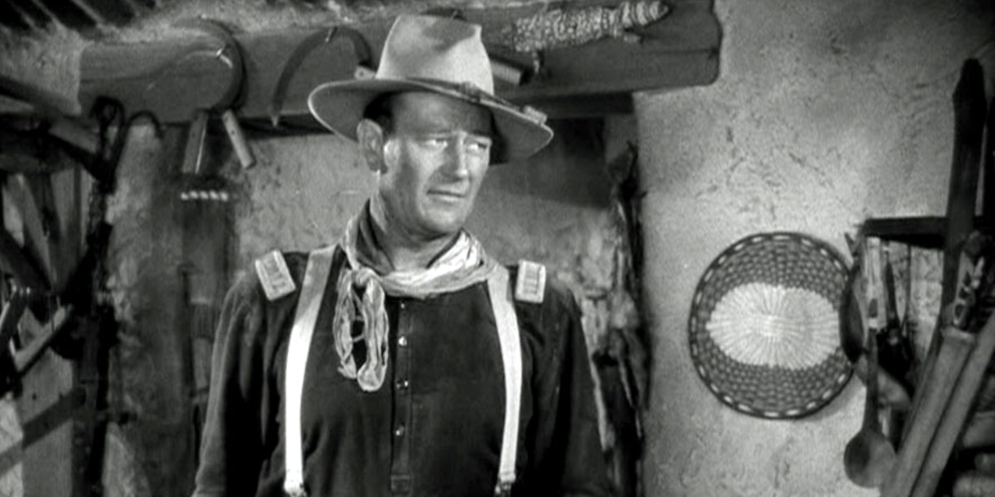John Wayne parado solo mirando hacia un lado en Fort Apache