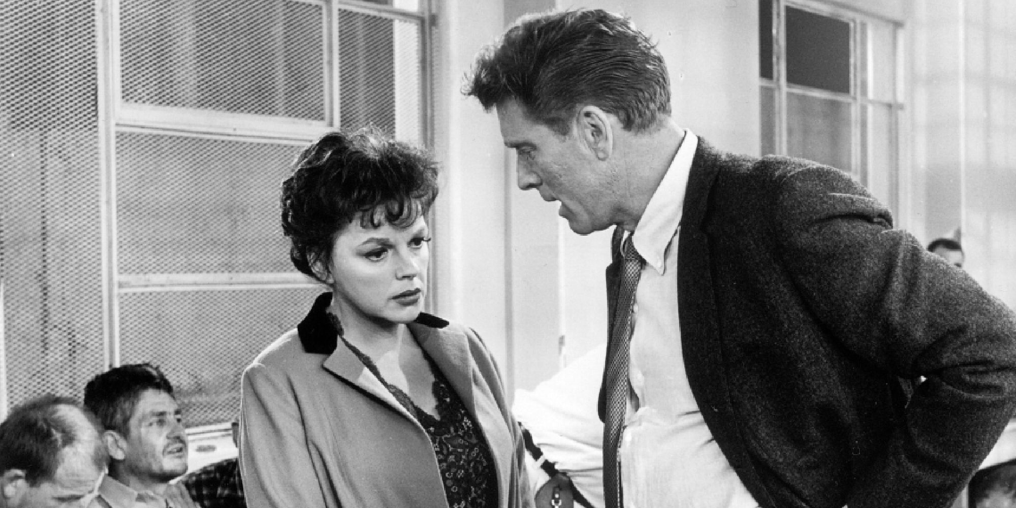 Judy Garland y Burt Lancaster como Matthew y Jean hablando afuera de un edificio en A Child is Waiting
