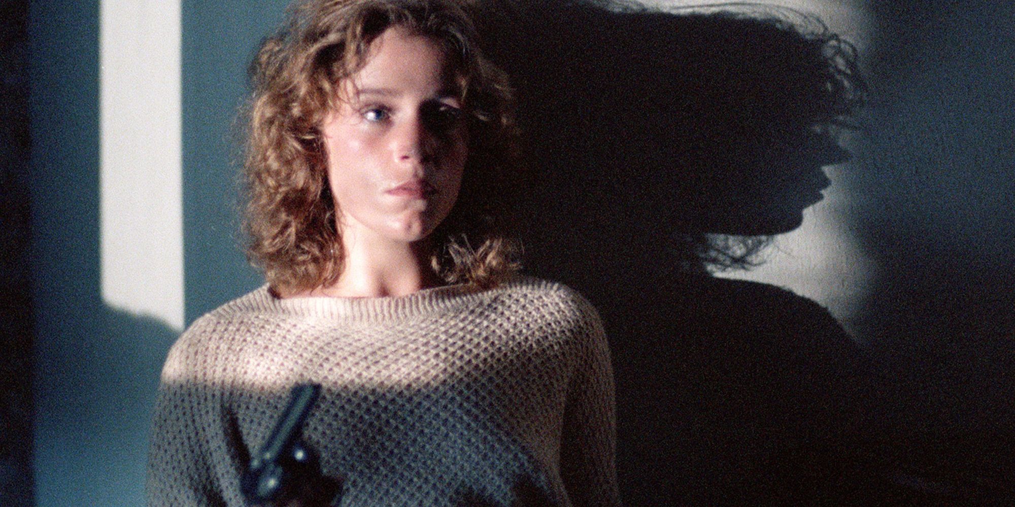 Frances McDormand as Abby holding a gun and looking scared in the film Blood Simple