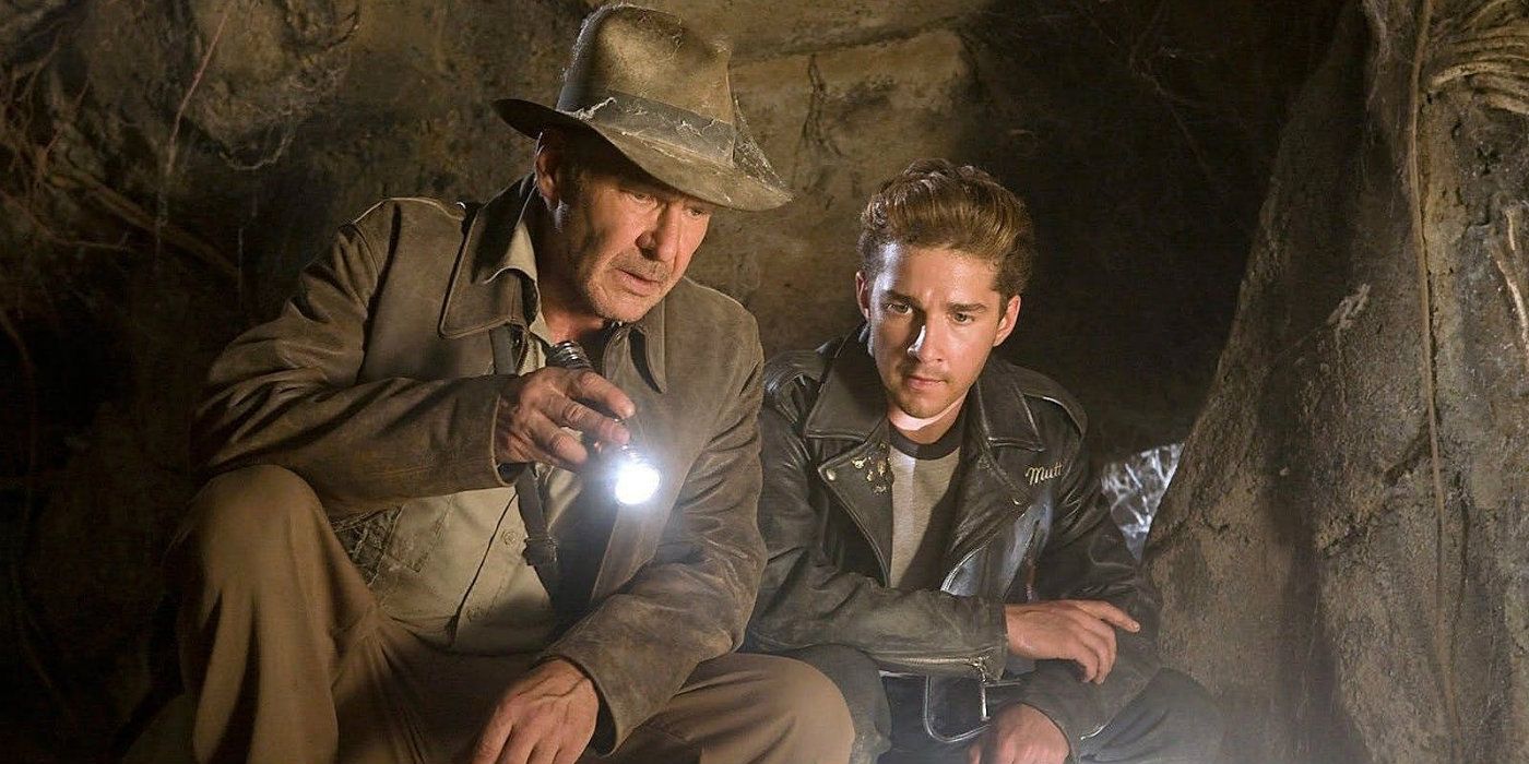 Harrison Ford como Indiana Jones y Shia LaBeouf como Mutt alumbrando con una linterna y examinando algo en una cueva en 'Indiana Jones y el Reino de la Calavera de Cristal'.