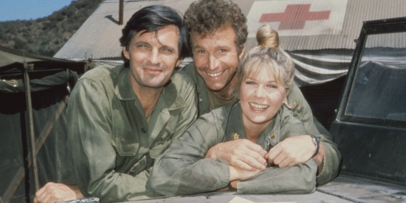 Los actores Alan Alda, Loretta Swit y Wayne Rogers apoyados en el capó de un vehículo militar en el set de M*A*S*H*