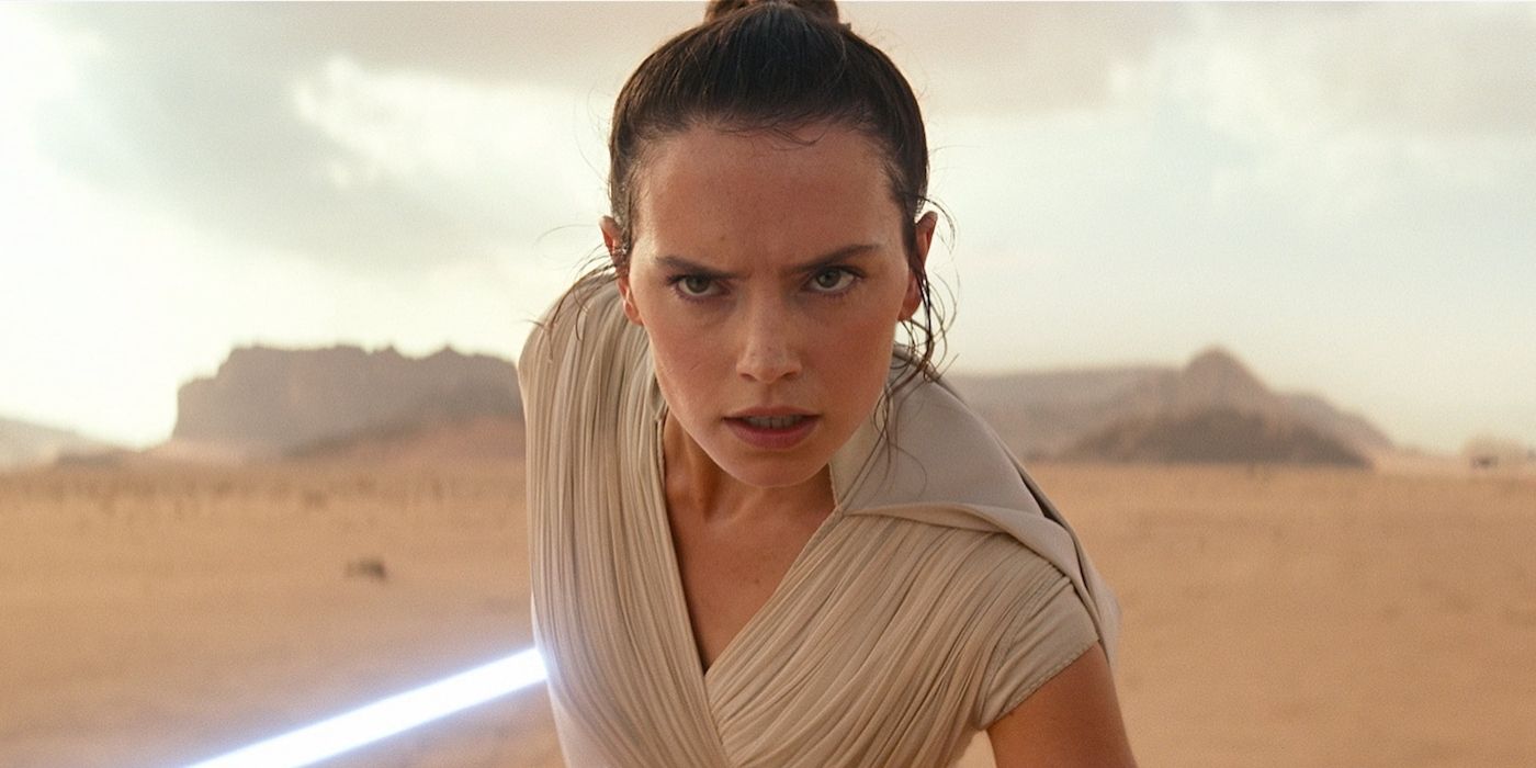 Daisy Ridley como Rey en The Rise of Skywalker sosteniendo un sable de luz detrás de ella.