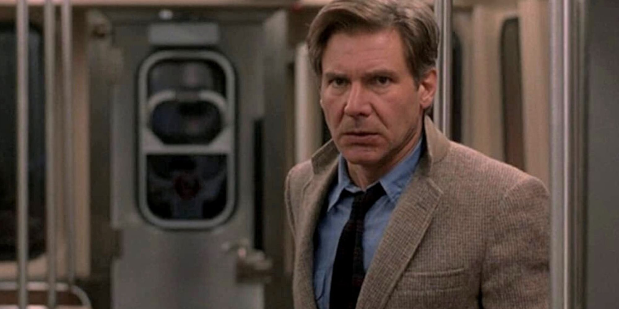 Richard Kimble standing alone in a subway car looking forward in The Fugitive