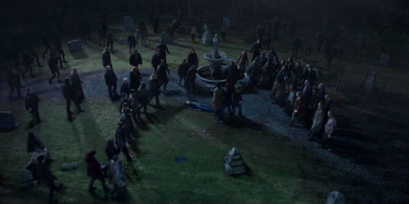 Sam, Dean, and Cas are crowded by a horde of zombies while Jack lies dead on the ground behind them.