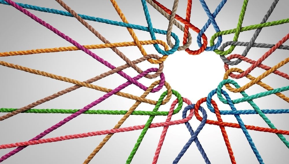 Coloridos trozos de cuerda en rojo, amarillo, verde, azul, marrón y morado están conectados entre sí de una manera que se forma con calor en el centro en una pieza sobre estrategias y conexiones de retención de clientes.