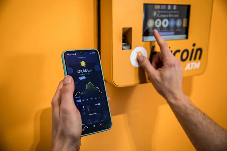 Un cliente inspecciona un gráfico de precios de Bitcoin mientras usa un cajero automático de criptomonedas (ATM) dentro de un intercambio de criptomonedas BitBase instalado en Barcelona, ​​​​España, el lunes 16 de mayo de 2022.dfd