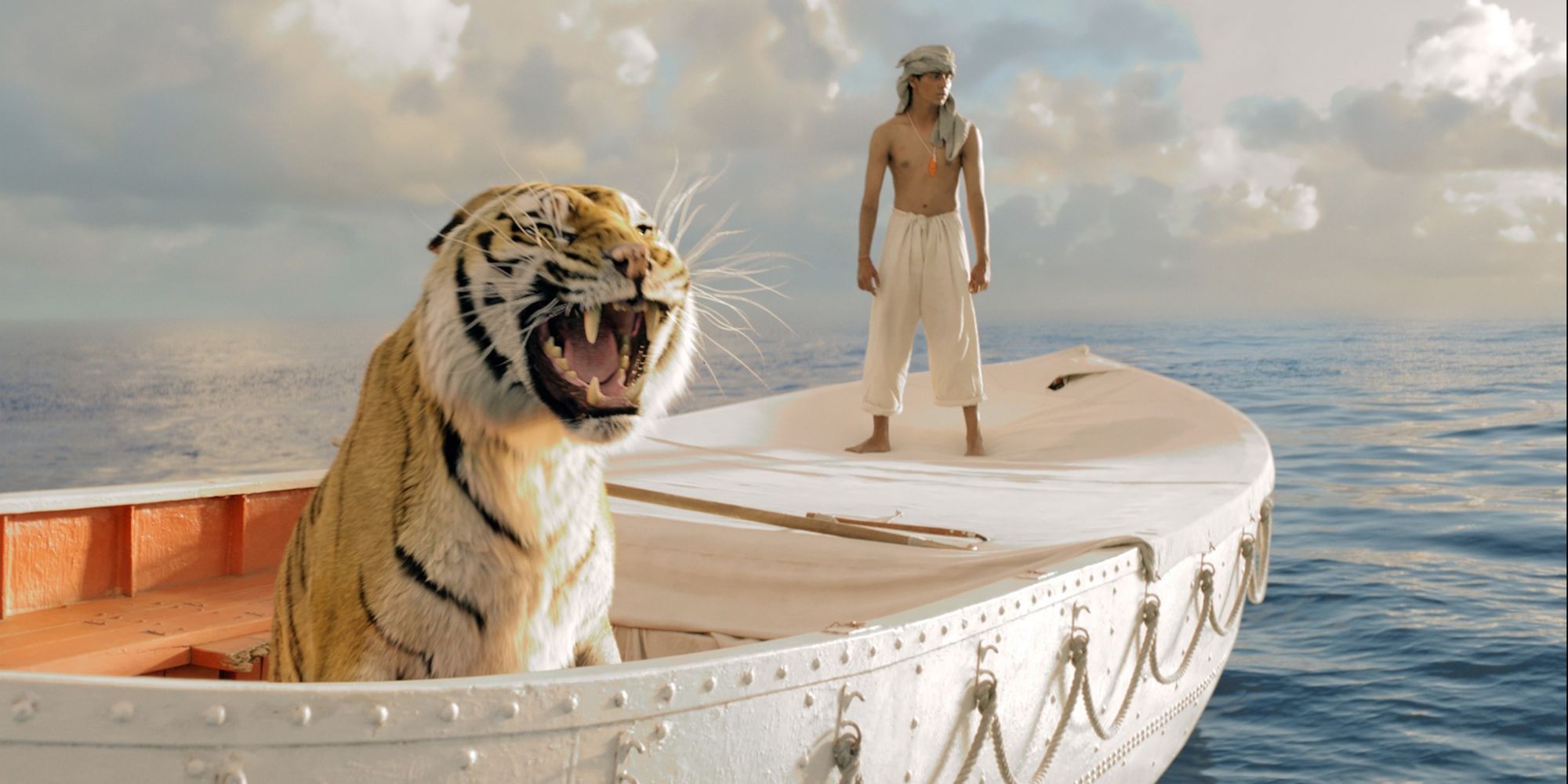 Pi (Suraj Sharma) looks over the boat with a tiger in Life of Pi (2012)